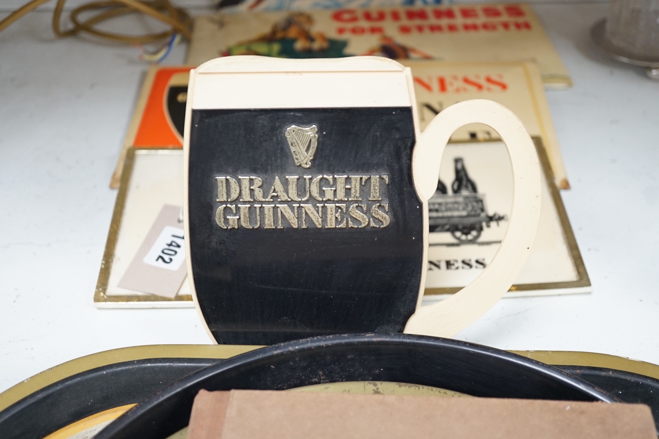 Five Guinness advertising signs, mirror, trays and a book - St. James’s Gate Brewery History and Guide